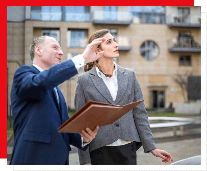 Two men in suits looking up at a building.