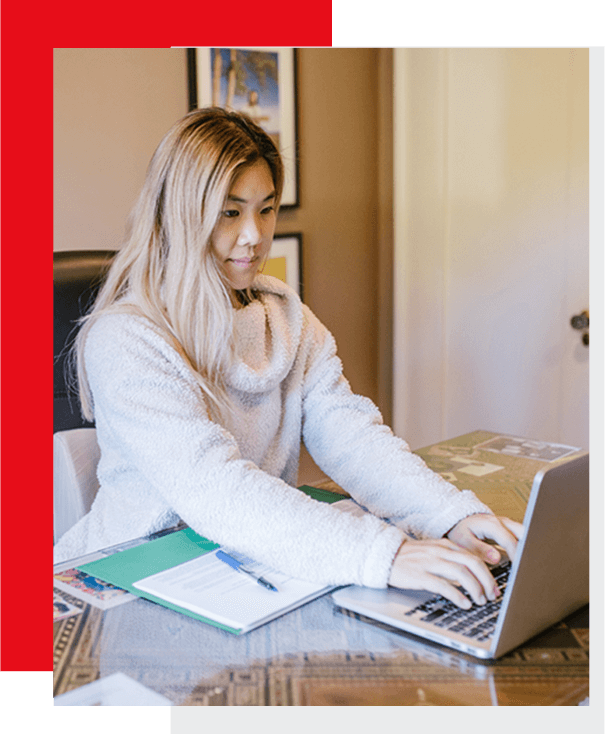 A woman sitting at her desk on the computer.