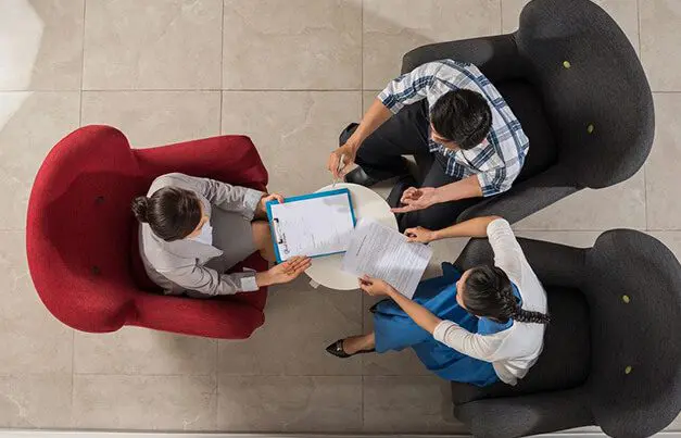 A group of people sitting around each other.